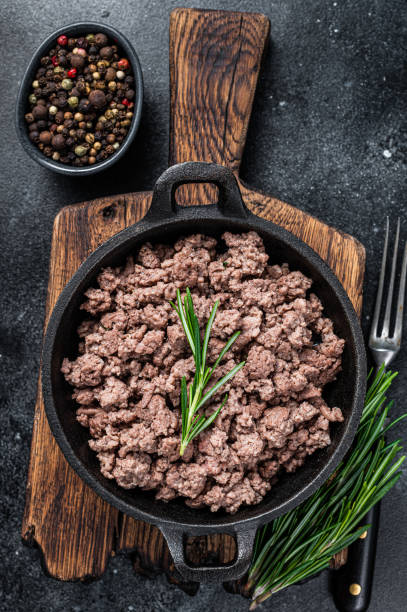 istock Fried mince beef meat in a pan for cooking pasta. Black background. Top view 1303679950