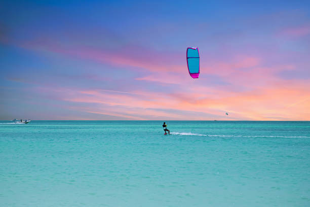 Kite surfing at Palm Beach on Aruba island in the Caribbean Sea Kite surfing at Palm Beach on Aruba island in the Caribbean Sea kiteboarding stock pictures, royalty-free photos & images