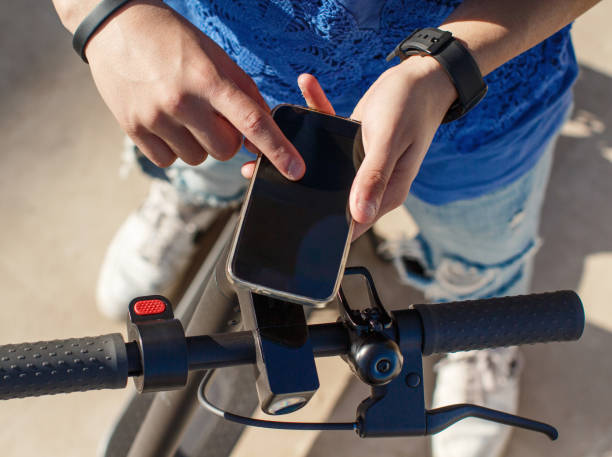istock Young man using smartphone to unlock a shared electric scooter 1303682650