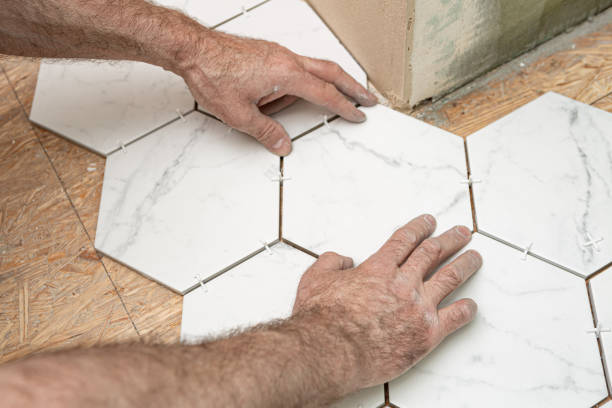 istock Renovation works - interior finishing worker (tiler) laying ceramic tiles on the floor 1303682785