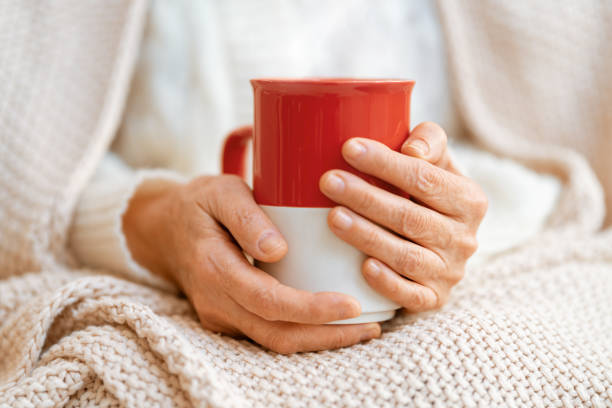 istock Senior woman with a mug in hands close up 1303682905