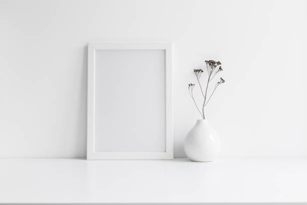 istock White frame and vase with decorative plant. Mock up. 1303683166