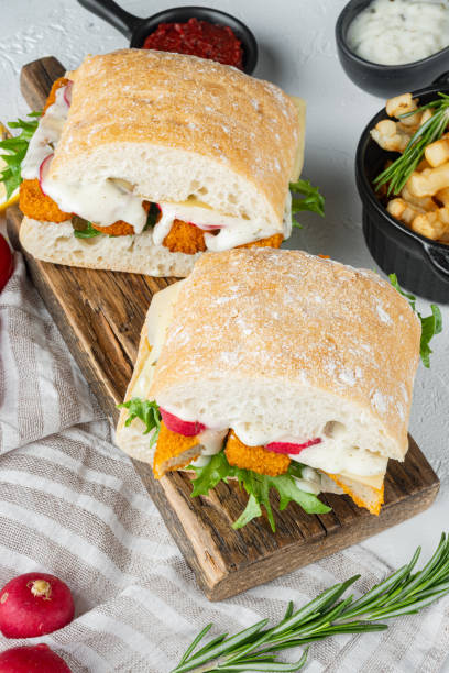 istock Fish fingers sandwich , on wooden cutting board, on white background 1303684475
