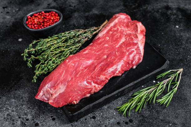 istock Raw flank beef meat steak. Black background. Top view 1303684546