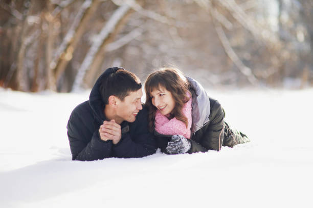 istock Happy couple lying on the snow and laughing 1303686640