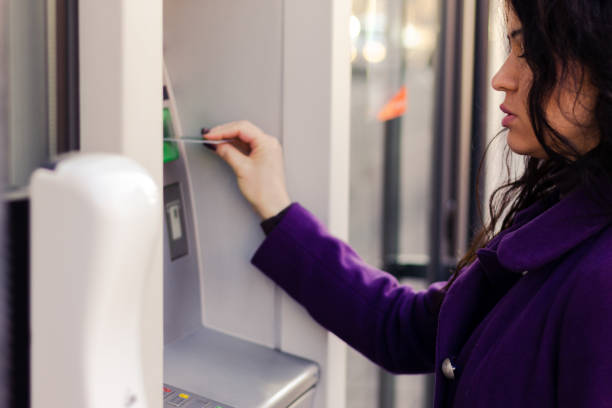 istock Adult woman is using a ATM. 1303687063