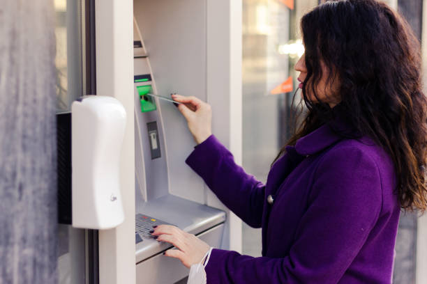 istock Adult woman is using a ATM. 1303687154