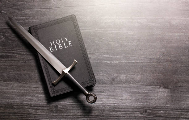 istock Bible and a Sword on a Dark Wooden Table 1303687294