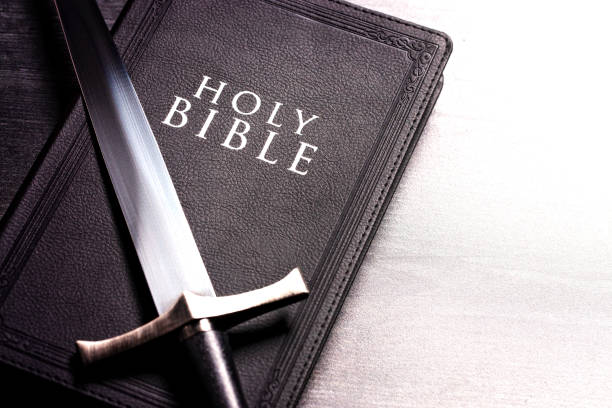 istock Bible and a Sword on a Dark Wooden Table 1303687323