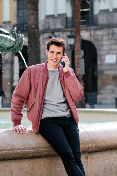 istock Young man talking on the phone outdoors on the street. 1303687330