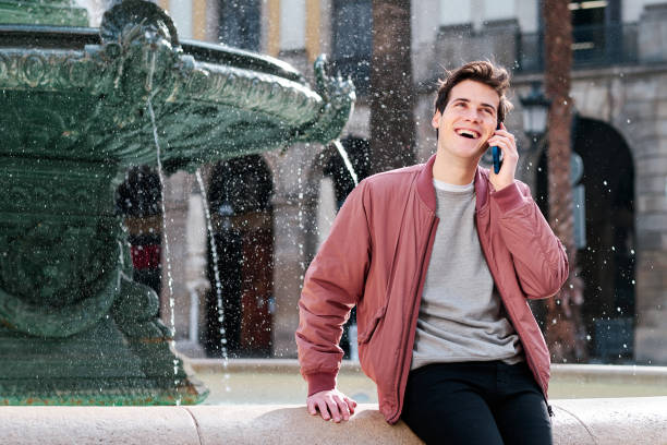 istock Young man talking on the phone outdoors. 1303687339