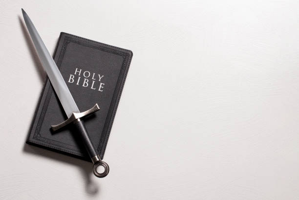 istock A Bible and Sword on a Bright White Background 1303687350