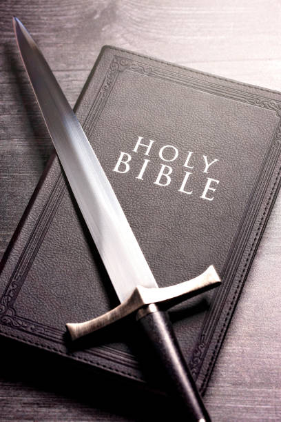istock Bible and a Sword on a Dark Wooden Table 1303687352