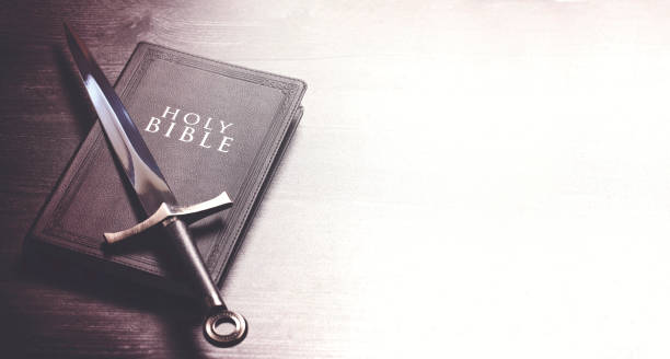 Bible and a Sword on a Dark Wooden Table