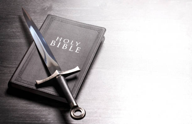 istock Bible and a Sword on a Dark Wooden Table 1303687402