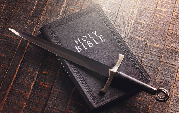 istock Bible and a Sword on a Dark Wooden Table 1303687413