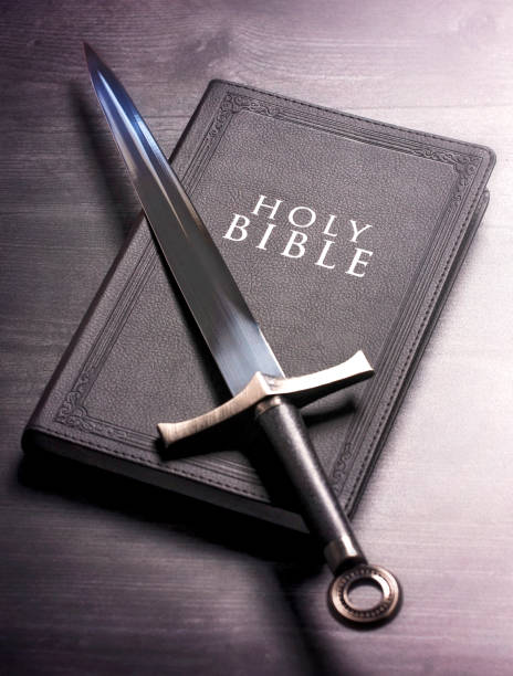 istock Bible and a Sword on a Dark Wooden Table 1303687417