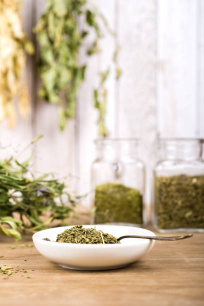 istock Herbal tea and dried herbs or medicine in jars with spoon 1303688974