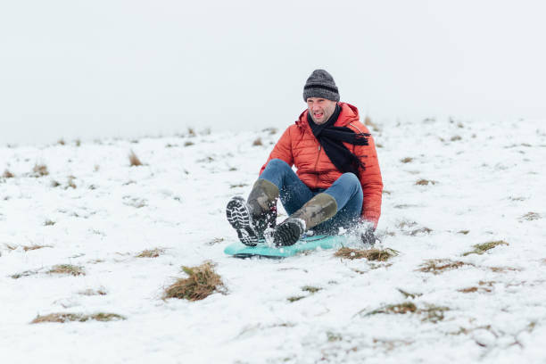 Mature Man Sledding Fast in the Snow