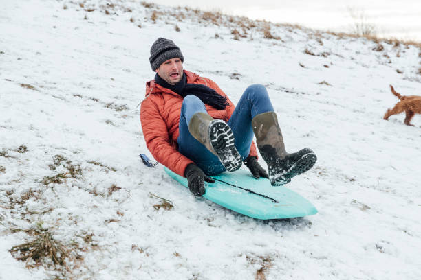 istock Mature Man Sledding Down a Snowy Hill 1303689641