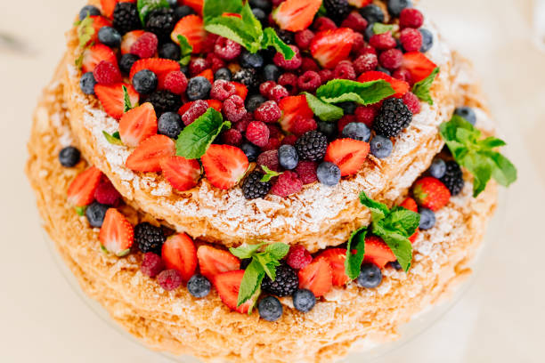 istock two-tier cake with strawberry, raspberry, blueberries, blackberries, mint leaves 1303691301