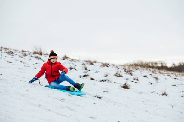 istock Young Boy Sledding in the Snow 1303691556