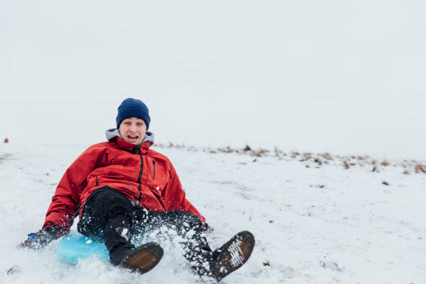 istock Young Man Sledding in the Snow 1303691648