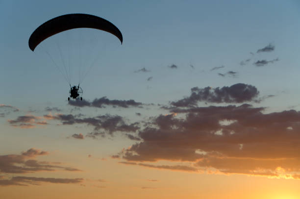 istock Silhouette of an ultralight flying at sunset 1303691868