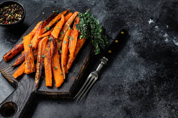 istock Roasted Sweet potatoes stripes. Black background. Top view. Copy space 1303692633