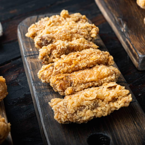 istock Spicy deep fried breaded chicken wings on dark wooden background 1303692807