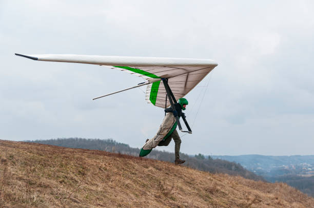 istock Hang glider pilot runs on the slope with his wing. 1303693091