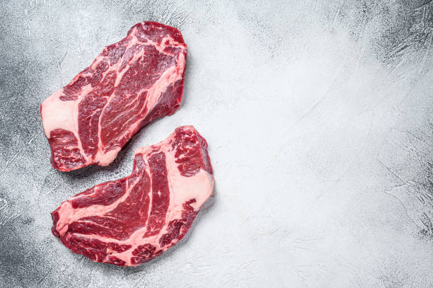 istock Raw chuck eye roll steaks premium beef meat. White background. Top view. Copy space 1303694027