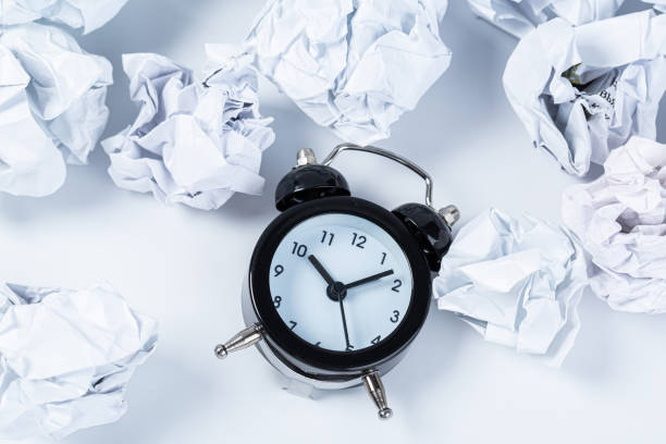 istock Alarm clock with crumpled paper balls.Timing and thinking idea concept. 1303695714