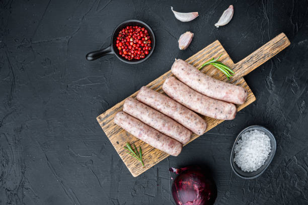 istock Homemade chicken sausages, top view with space for text, on black background 1303695875