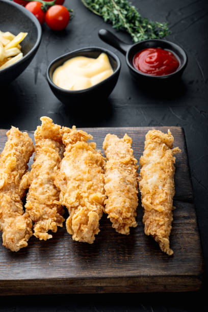 istock Deep fried crunchy spicy chicken on black background 1303696995