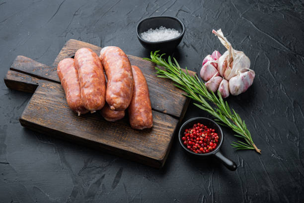 istock Traditional raw pork sausages, on black background 1303697216