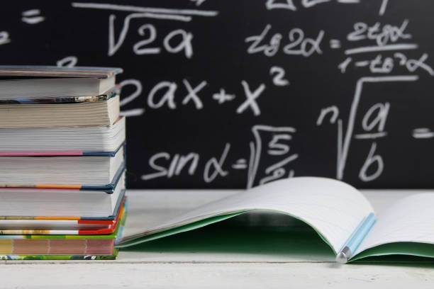 istock Books and notebook on blackboard background with mathematical formulas. Education concept. 1303698702