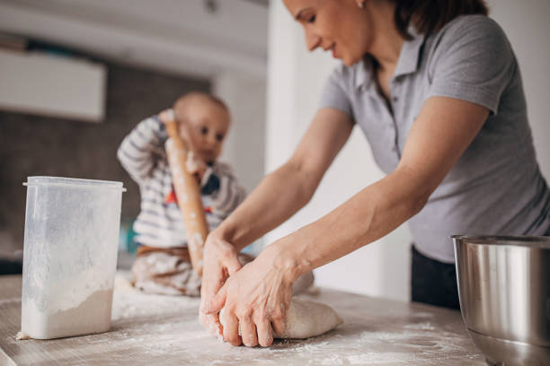 istock Mother and baby boy having fun making dough 1303700158