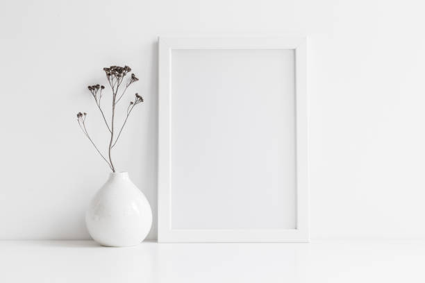 istock Picture frame mock up and vase with decorative plant. 1303701400