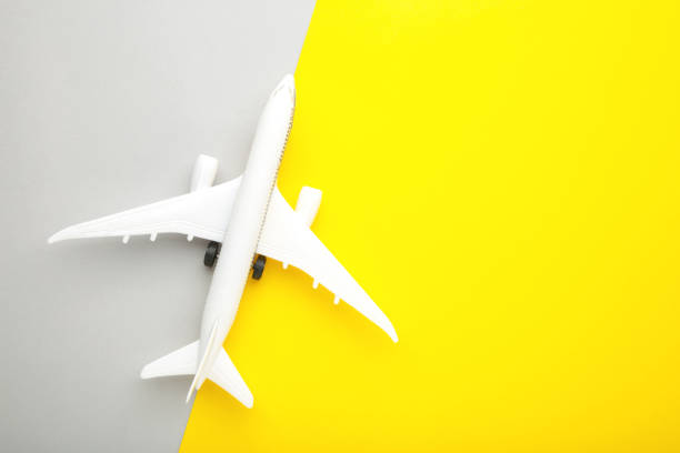 istock Model airplane on yellow and grey background. 1303702277