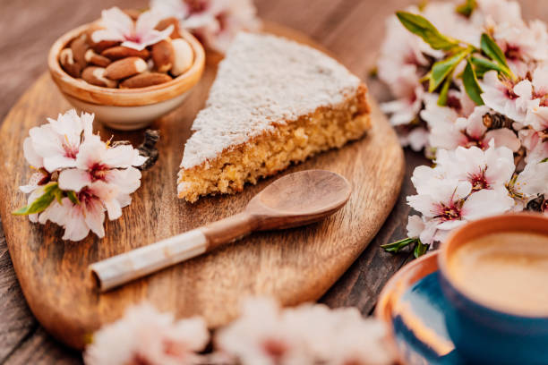 Close up of Mallorcan almond cake called Gató adorned with almond blossoms and served with Spanish coffee stock photo