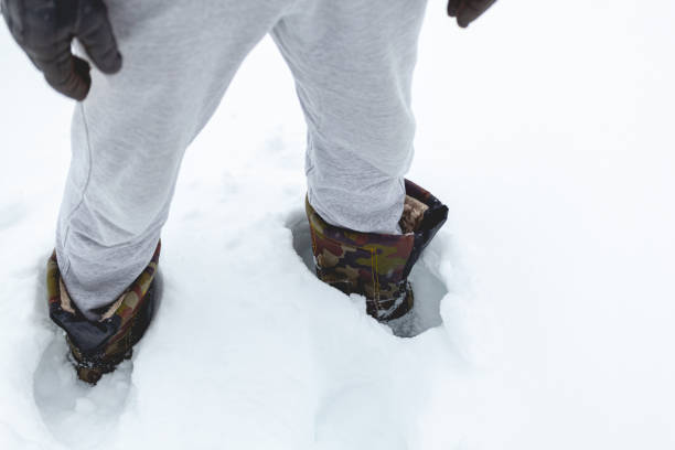 istock man in boots stands in deep snow 1303706056