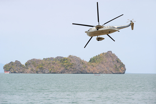 Malaysia,Lang Kawi 10 january 2020;   Rotorcraft rotating above the andaman sea near the coast line, in the background a uninhabited small island.