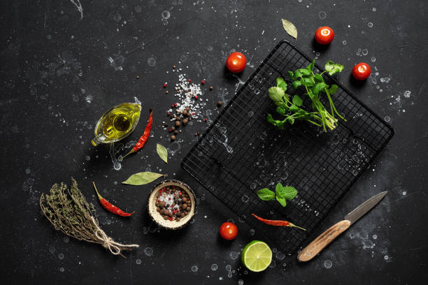 istock Black culinary background. Spices, herbs, vegetables, oil. Ingredients for cooking. Top view, flat lay, 1303708741