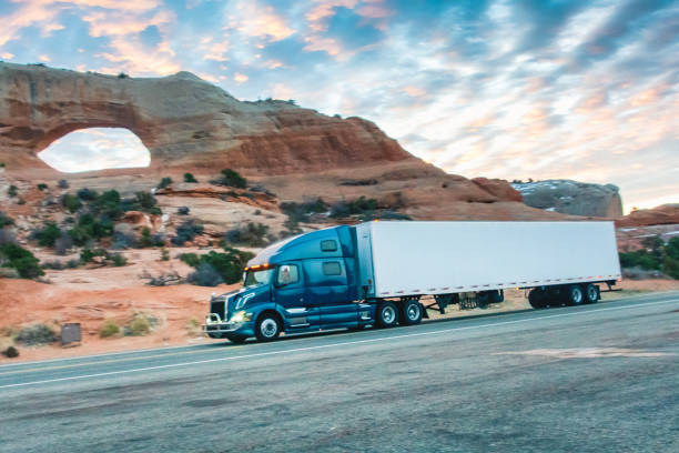 istock Long Haul Semi Trucks on A Two Way Highway 1303709457
