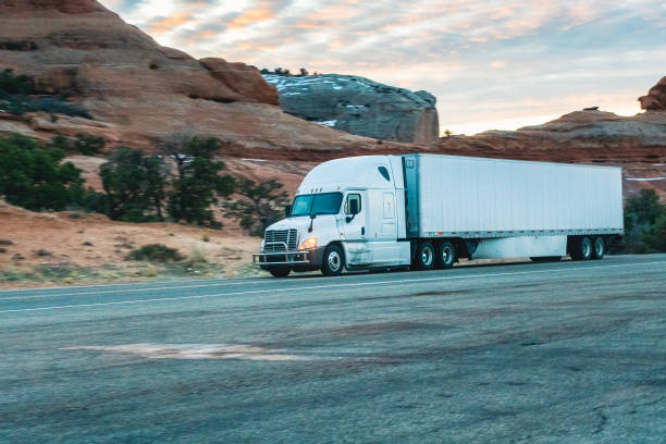 istock Long Haul Semi Trucks on A Two Way Highway 1303709469