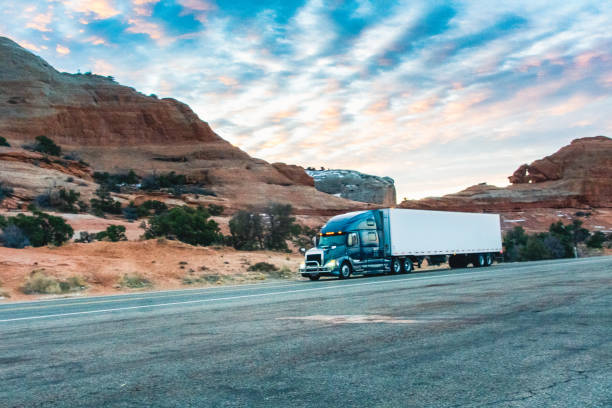 istock Long Haul Semi Trucks on A Two Way Highway 1303709515