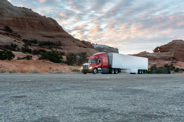 istock Long Haul Semi Trucks on A Two Way Highway 1303709517