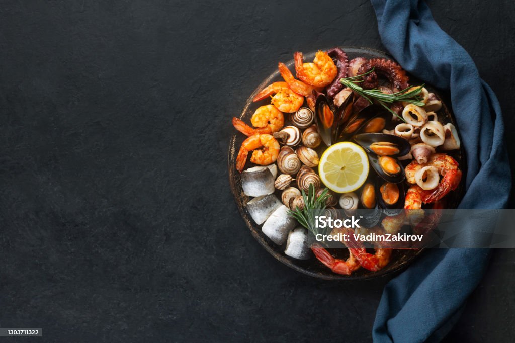 Seafood charcuterie board with shrimp, oysters, fish and octopus with copy space Seafood charcuterie platter board with shrimp, oysters, fish and octopus on black background and free space Seafood Stock Photo