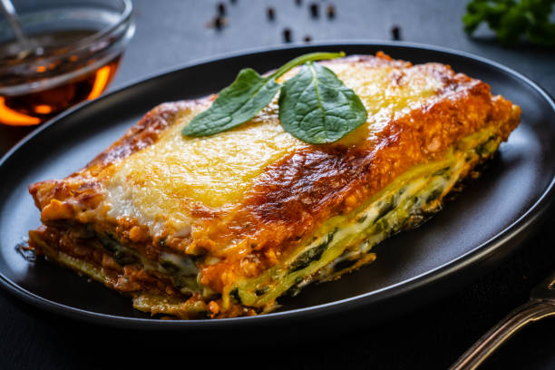 istock Lasagna with pork and spinach on black table 1303712746